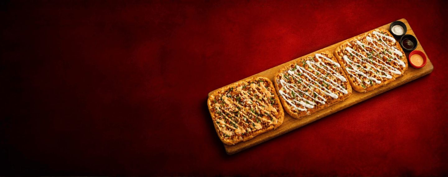 Three-flavour Train Pizza on a wooden board with three dips